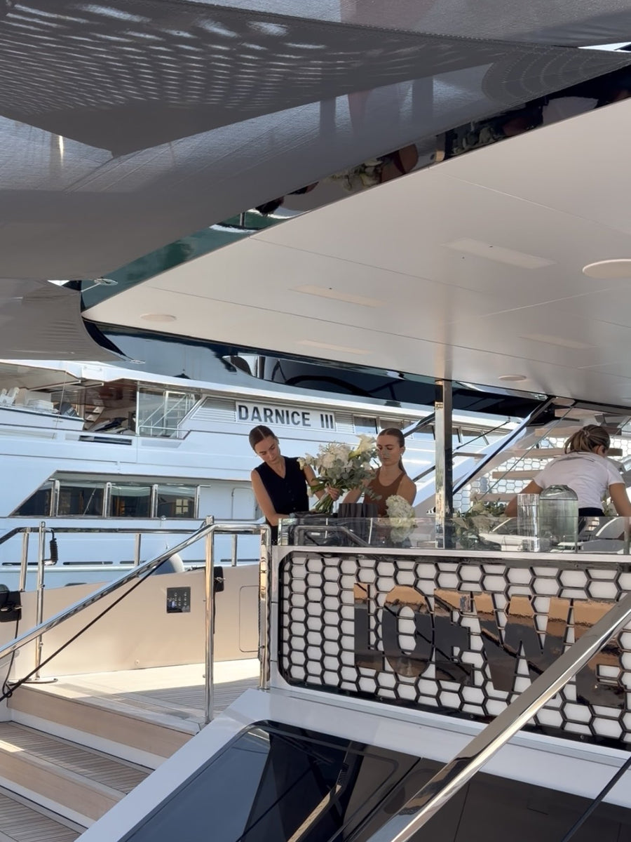 Fioriste al lavoro sul ponte di uno yacht in porto