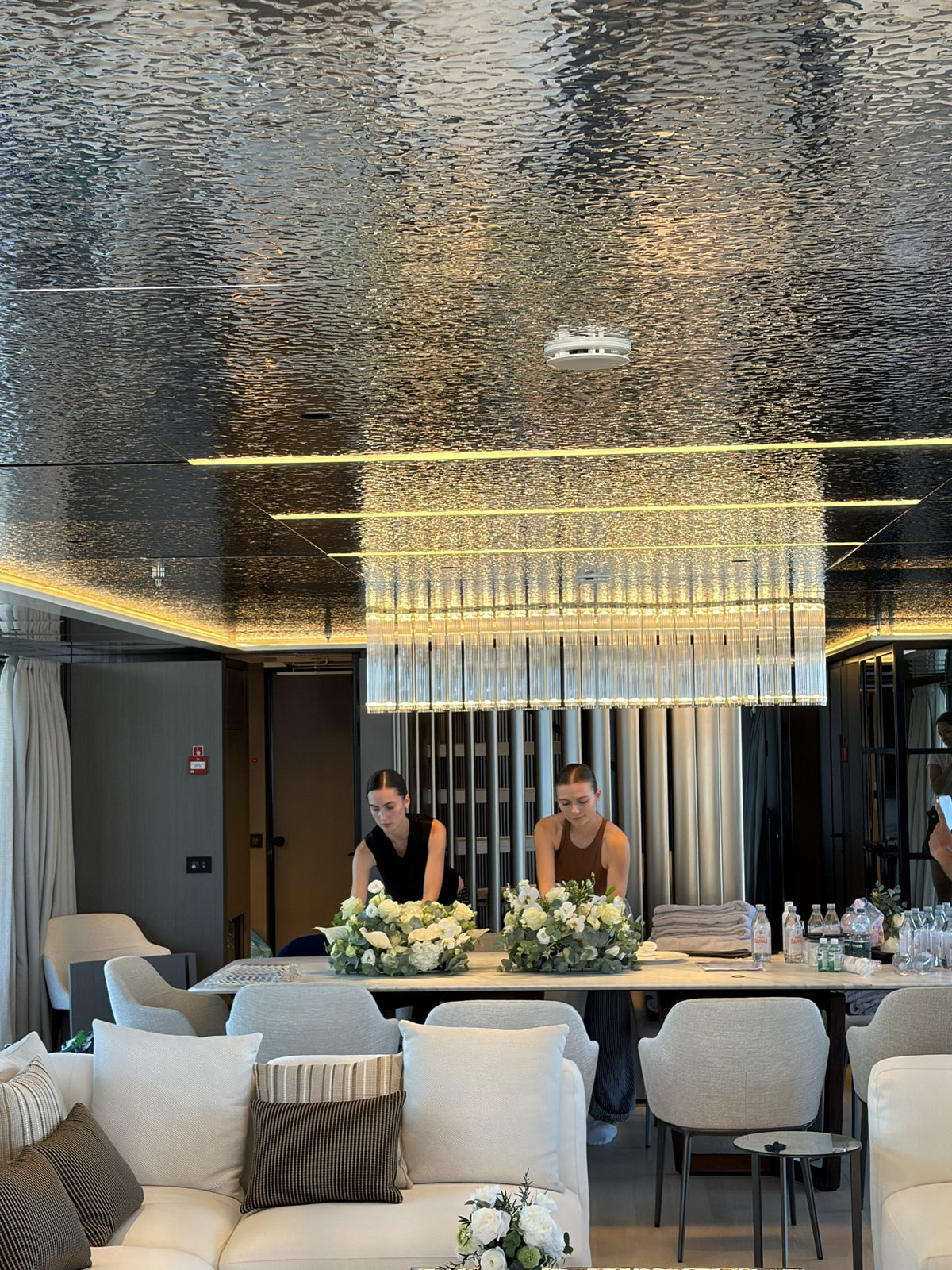 Le fioriste di Fiorisci allestiscono i centrotavola bianchi nel salone di uno yacht